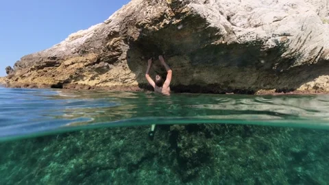 Boy climbing rock split shot over under half underwater Vídeos de archivo 338181051