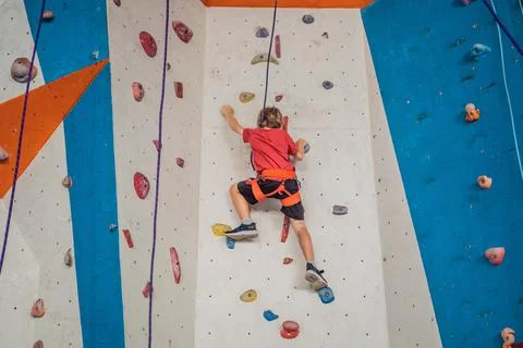 Boy at the climbing wall without a helmet, danger at the climbing wall Stock Photos