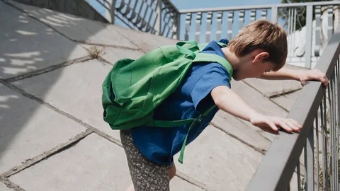 The boy climbs on the bridge support to bypass the stairs Stock Footage 113071959