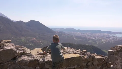 The boy climbs the rocks at the cliff and dismantles his power Stock Footage 124715897