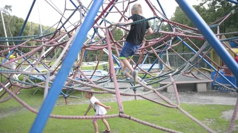 Boy climbs on the ropes in the ropes course - summer fun Stock Footage 66278419