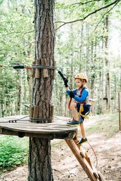 Boy climbs the stairs to a platform on a tree Stock Photos