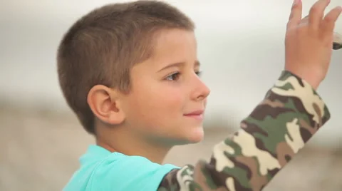 Boy with closed eyes sitting on the beach Stock Footage 68757585