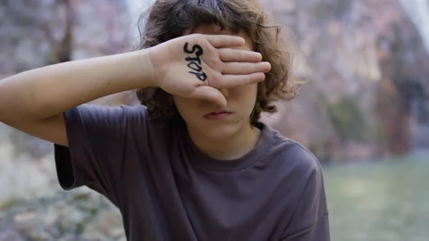 The boy closed his eye with his hand on which the inscription stop is written Stock Footage 191463973