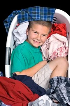 Boy in clothes basket Stock Photos