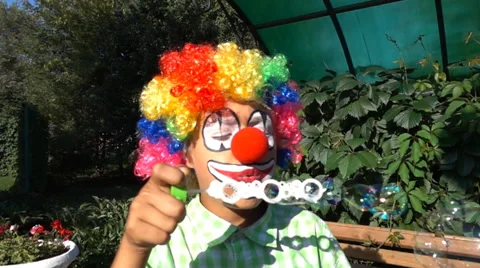 Boy clown blowing soap bubbles slow motion Stock Footage 65829300