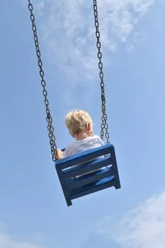 A Boy With Cochlear Implants Riding Swing in Park Stock Photos