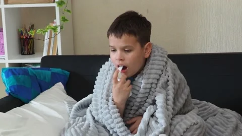 A boy with a cold is at home, being treated. medicines, throat and nose spray 库存影片 164471596