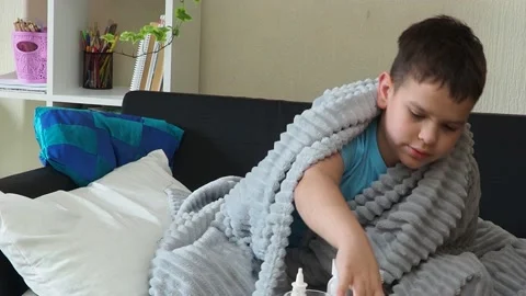A boy with a cold is at home, being treated. medicines, throat and nose spray Stock Footage 164471652