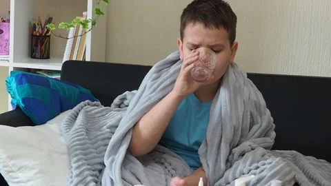 A boy with a cold is at home, being treated. medicines, throat and nose spray 库存影片 164471712