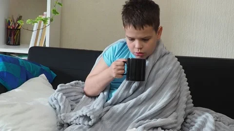 A boy with a cold is at home, being treated. medicines, throat and nose spray 库存影片 164471756