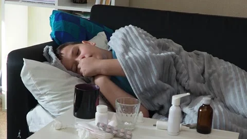 A boy with a cold is at home, being treated. medicines, throat and nose spray 库存影片 164471791