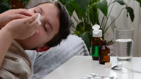 A boy with a cold is at home, treated. medicines, medicine, throat nose spray 库存影片 148771293