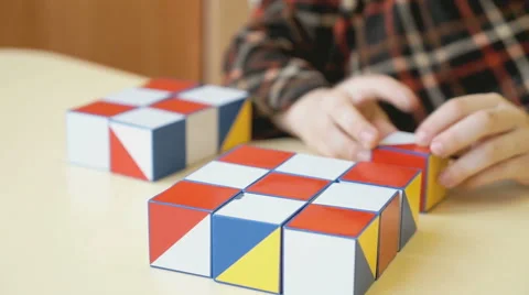 A boy collecting a pattern using colored cubes 스톡 동영상 64034376