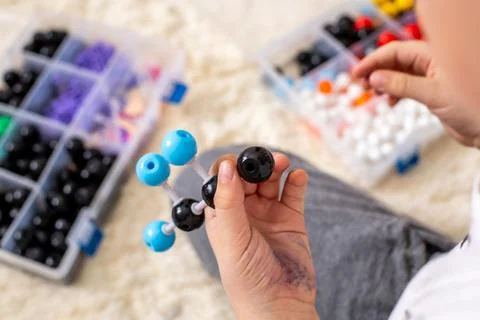 The boy collects a propane molecule model from the constructor using the formula Stock Photos