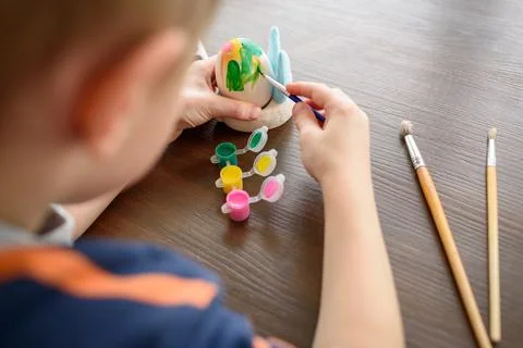 Boy coloring Easter egg Stock Photos