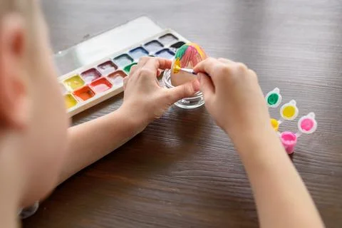 Boy coloring Easter egg Stock Photos