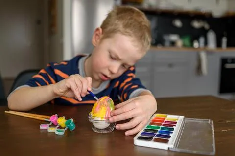 Boy coloring Easter egg Stock Photos