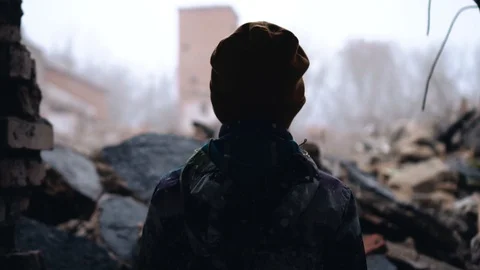 The boy comes out of the destroyed house and watches the devastation Stock Footage 126299987