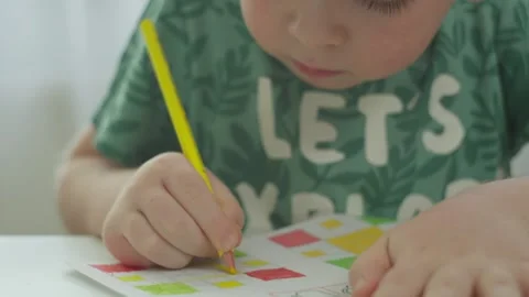 The boy concentrates on drawing the task in yellow. Stock Footage 245205527