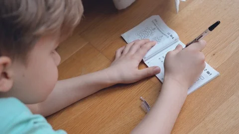 Boy concentrating and thinking. Child studying homework and writing Video stock 123201734