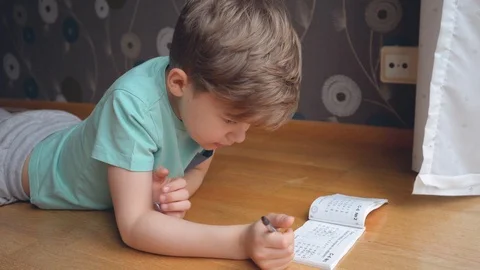 Boy concentrating and thinking. Child studying homework and writing Video stock 123201832