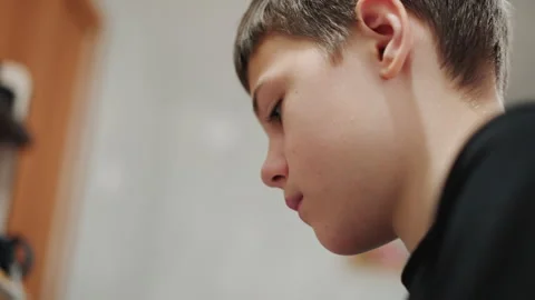 Boy concentrating in study session. Serene young student immersed in quiet study Stock Footage 345148899