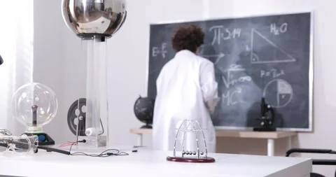 A boy conducts physical experiments with electricity, a plasma ball, and a Van Stock Footage 173394684