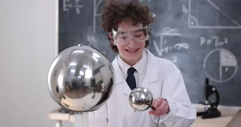A boy conducts physical experiments with electricity, a plasma ball, and a Van Stock Footage 176198526