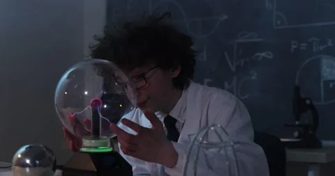 A boy conducts physical experiments with electricity, a plasma ball, and a Van Stock-Footage 176203144