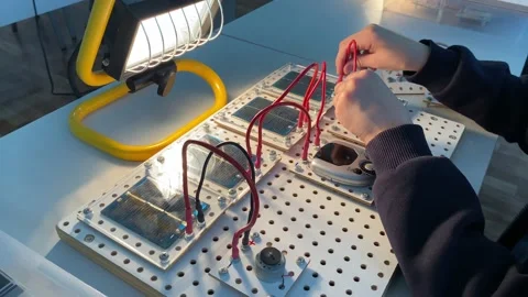 Boy is connecting wires to solar panels at school electronic or physics lesson Stock Footage 220806385