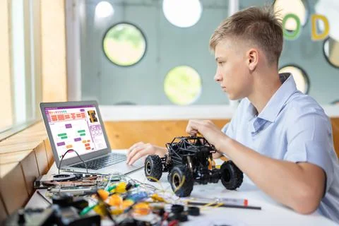 Boy consider code on laptop screen learn technology in STEM class. Edification. Stock Photos