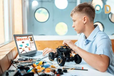 Boy consider code on laptop screen learn technology in STEM class. Edification. Stock Photos