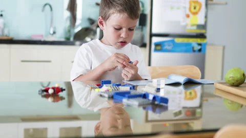 Boy constructing with cubes in living room. Video stock 265436397
