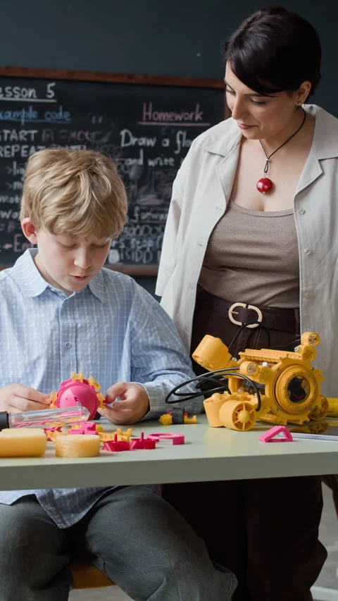 Boy Constructing Robotic Toy with Teacher in Robotics Classroom Stock Footage 339206848