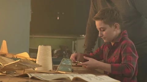 A boy constructs an airplane under the guidance of a teacher 库存影片 171012179
