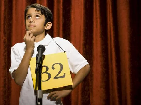 Boy contestant standing at microphone thinking Foto stock