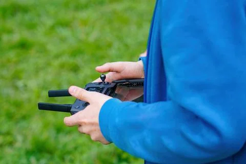 The boy controls the flight of the quadcopter using the remote control. Stock Photos