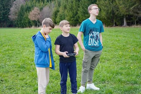 The boy controls the flight of the quadcopter using the remote control. Foto stock