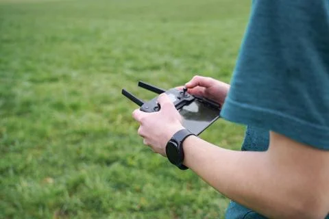 The boy controls the flight of the quadcopter using the remote control. Stock-Fotos