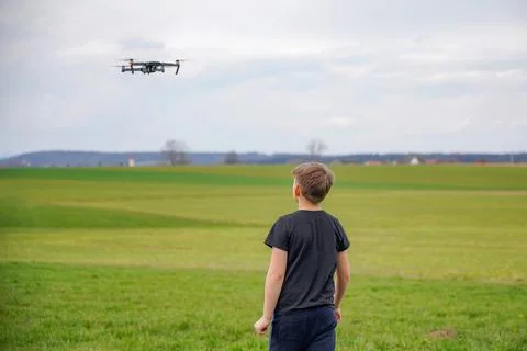 The boy controls the flight of the quadcopter using the remote control. Foto stock