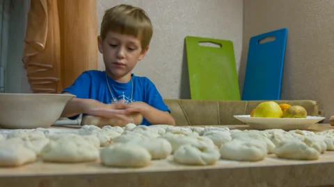 A boy is cooking meat pies Stock Footage 142396896