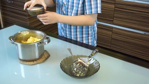 Boy cooks mashed potatoes in the kitchen on the table Stock Footage 99224423