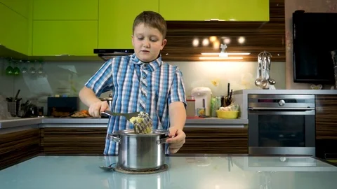 Boy cooks mashed potatoes in the kitchen on the table Stock Footage 99225777