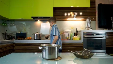 Boy cooks mashed potatoes in the kitchen on the table Stock Footage 99225867