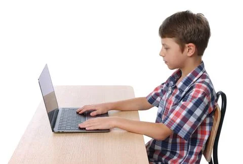 Boy with correct posture using laptop at wooden desk on white background Stock Photos