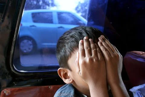 A boy covering face with hands Foto stock