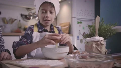 Boy cracks an egg. two children sister and brother cooking and baking at home.  Stock Footage 145203863