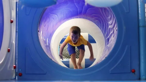 Boy crawls trough pipe. Plastic tunnel. Video stock 264756781