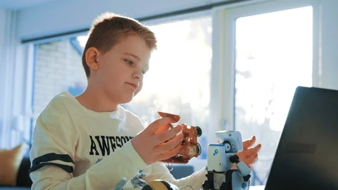 Boy creates a robot and tries to make a circuit board fit into his design Stock Footage 102181036